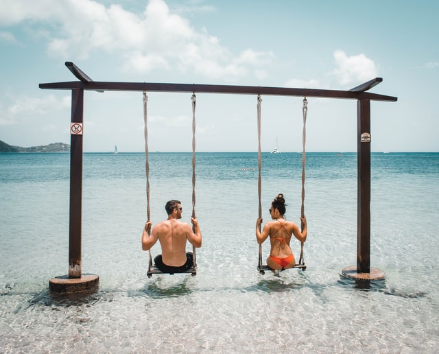 Couple In Swings On Beach